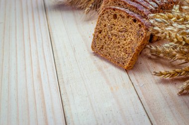 Ekmek kes. Buğday tohumu kulaklı bir somun taze ekmek ya da ahşap desenli bir bitki. Çavdar ekmeği ve ekmek kırıntılarıyla. Biyolojik malzemeler, çok sağlıklı tohumlar..