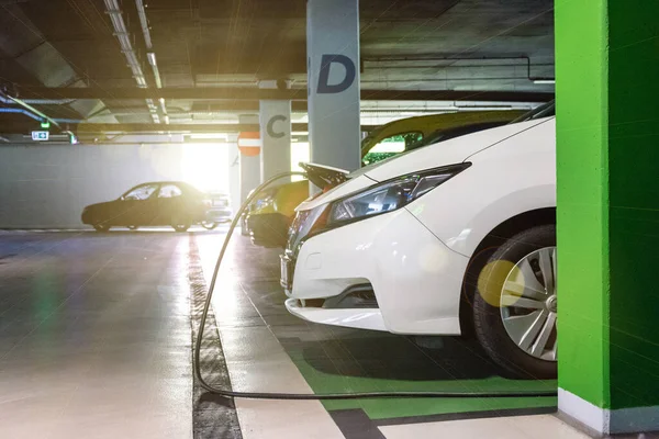 Milieuvriendelijke auto. Hybride voertuig - groene technologie van de toekomst. Batterijlading elektrische auto op eco-energieoplader station. Schone energie toekomst van transport ecologie concept. — Stockfoto