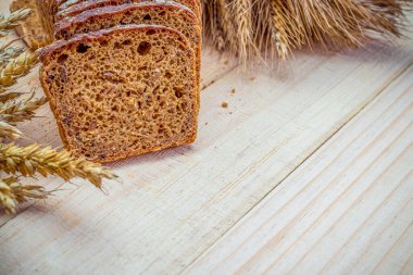 Köy ekmeği. Buğday tohumu kulaklı bir somun taze ekmek ya da ahşap desenli bir bitki. Çavdar ekmeği ve ekmek kırıntılarıyla. Konsept - Evde Yemek Pişirme.