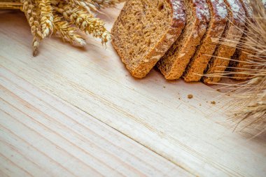 Çavdar ekmeği. Kabuklu somun ve ekmek kırıntılarıyla fırın. Buğday tohumu kulaklı bir somun rustik ekmek ya da doğal ahşap arka planda çavdar mahsulü bitki. Sağlıklı gıda konsepti.