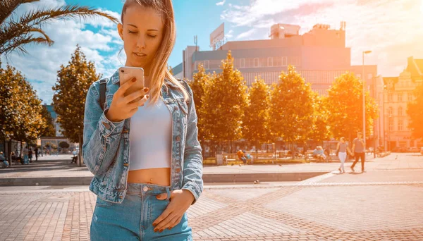 Taking picture. Happy young girl with phone smile, typing texting and taking selfie in summer sunshine urban city. Pretty female taking fun self portrait photo. Vanity, social network concept. — Stock Photo, Image