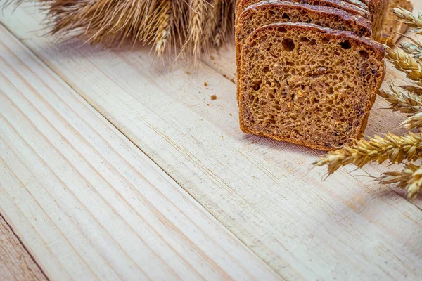Çavdar ekmeği izole. Kabuklu somun ve ekmek kırıntılarıyla fırın. Buğday tohumu kulaklı taze bir somun ekmek ya da doğal ahşap arka planda çivili bitki. Biyolojik malzemeler, tohumlarla sağlıklı..
