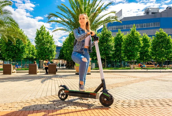 Şehir scooter 'ı. İş kadınının kullandığı elektrikli bisikleti tekmele. Avrupa şehir merkezinde toplu taşıma. — Stok fotoğraf