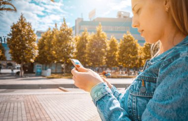 Selfie yapıyorum. Güzel bir kadın, eğlenceli bir oto portre fotoğrafı çekiyor. Telefon tebessümlü, daktilo eden ve yaz güneşli kentlerde selfie çeken mutlu bir genç kız. İnsanlar seyahat teknolojisi.