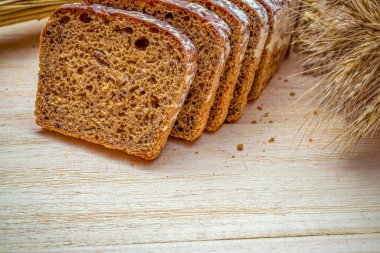 Köy ekmeği. Buğday tohumu kulaklı bir somun taze ekmek ya da ahşap desenli bir bitki. Çavdar ekmeği ve ekmek kırıntılarıyla. Konsept - Evde Yemek Pişirme.