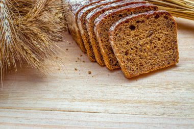 Çavdar ekmeği. Kabuklu somun ve ekmek kırıntılarıyla fırın. Buğday tohumu kulaklı bir somun rustik ekmek ya da doğal ahşap arka planda çavdar mahsulü bitki. Sağlıklı gıda konsepti