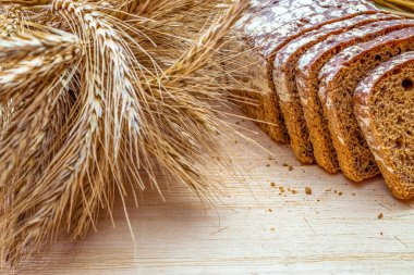 Ekmek kes. Buğday tohumu kulaklı bir somun taze ekmek ya da ahşap desenli bir bitki. Çavdar ekmeği ve ekmek kırıntılarıyla. Biyolojik malzemeler, çok sağlıklı tohumlar.