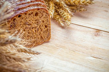Taze pişmiş ekmek. Buğday tohumu kulaklı bir somun taze ekmek ya da ahşap desenli bir bitki. Çavdar ekmeği ve ekmek kırıntılarıyla. Sağlıklı gıda konsepti