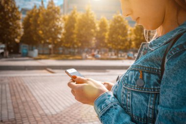 Şık kadın manzarası. Telefon tebessümlü, daktilo eden ve yaz güneşli kentlerde selfie çeken mutlu bir genç kız. Modern teknoloji dişlek kahkaha dinlenme rahat yaşam tarzı konsepti