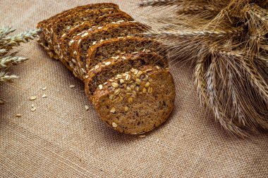 Buğday ekmeği. Buğday tohumu kulaklı bir somun taze ekmek ya da keten desenli bir bitki. Çavdar ekmeği ve ekmek kırıntılarıyla. Ev yapımı pişirme.