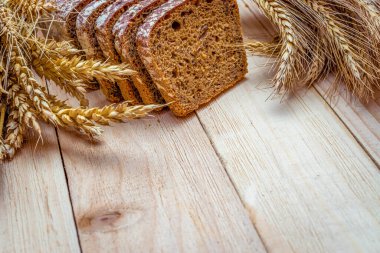 Lezzetli ekmek. Buğday tohumu kulaklı bir somun taze ekmek ya da ahşap desenli bir bitki. Çavdar ekmeği ve ekmek kırıntılarıyla. Ev yapımı pişirme.