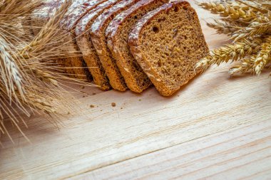 Taze pişmiş ekmek. Buğday tohumu kulaklı bir somun taze ekmek ya da ahşap desenli bir bitki. Çavdar ekmeği ve ekmek kırıntılarıyla. Sağlıklı gıda konsepti
