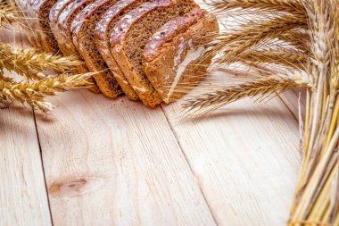 Somun ekmek. Çavdar ekmeği ve ekmek kırıntılarıyla. Buğday tohumu kulaklı taze bir somun ekmek ya da doğal ahşap arka planda çivili bitki. Biyolojik malzemeler, çok sağlıklı tohumlar.