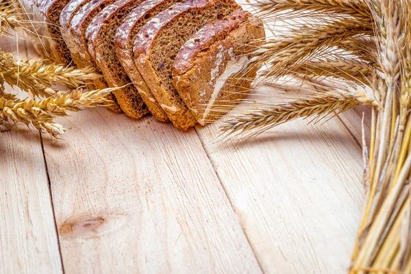 Somun ekmek. Çavdar ekmeği ve ekmek kırıntılarıyla. Buğday tohumu kulaklı taze bir somun ekmek ya da doğal ahşap arka planda çivili bitki. Biyolojik malzemeler, çok sağlıklı tohumlar.