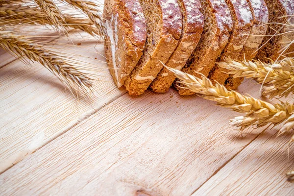 Ekmek kes. Buğday tohumu kulaklı bir somun taze ekmek ya da ahşap desenli bir bitki. Çavdar ekmeği ve ekmek kırıntılarıyla. Biyolojik malzemeler, çok sağlıklı tohumlar.