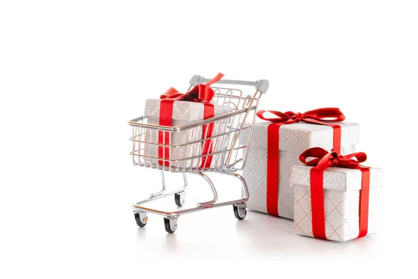 Χριστουγεννιάτικη πώληση. Τρόλεϊ καλάθι για σούπερ μάρκετ με χριστουγεννιάτικο δώρο ή κουτί γενεθλίων απομονώνονται σε λευκό φόντο. Online valentine, Χριστούγεννα έννοια ψώνια. — Φωτογραφία Αρχείου