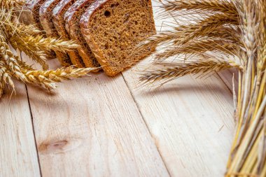 Köy ekmeği. Buğday tohumu kulaklı bir somun taze ekmek ya da ahşap desenli bir bitki. Çavdar ekmeği ve ekmek kırıntılarıyla. Konsept - Evde Yemek Pişirme