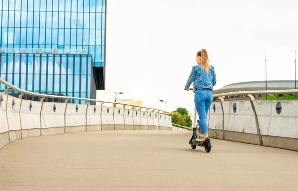 Scooter doğası. İş kadınlarının kullandığı elektrikli şehir bisikletini tekmele. Kamu paylaşımı için elektrikli scooterlar dışarıda duruyor