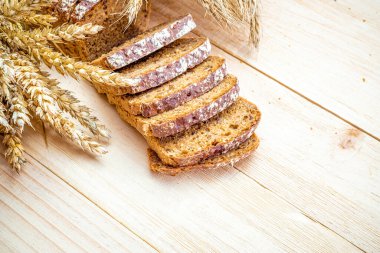 Buğday ekmeği. Buğday tohumu kulaklı bir somun taze ekmek ya da ahşap desenli bir bitki. Çavdar ekmeği ve ekmek kırıntılarıyla. Ev yapımı pişirme.