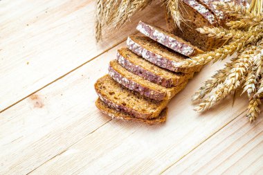 Somun ekmek. Çavdar ekmeği ve ekmek kırıntılarıyla. Buğday tohumu kulaklı taze bir somun ekmek ya da doğal ahşap arka planda çivili bitki. Biyolojik malzemeler, çok sağlıklı tohumlar.