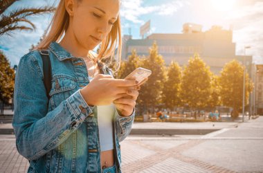 Selfie çeken kadın. Telefon tebessümlü, daktilo eden ve yaz güneşli kentlerde selfie çeken mutlu bir genç kız. Güzel bir kadın, eğlenceli bir oto portre fotoğrafı çekiyor. Kibir, sosyal ağ kavramı