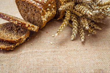 Taze pişmiş ekmek. Buğday tohumu kulaklı bir somun taze ekmek ya da keten desenli bir bitki. Çavdar ekmeği ve ekmek kırıntılarıyla. Sağlıklı gıda konsepti