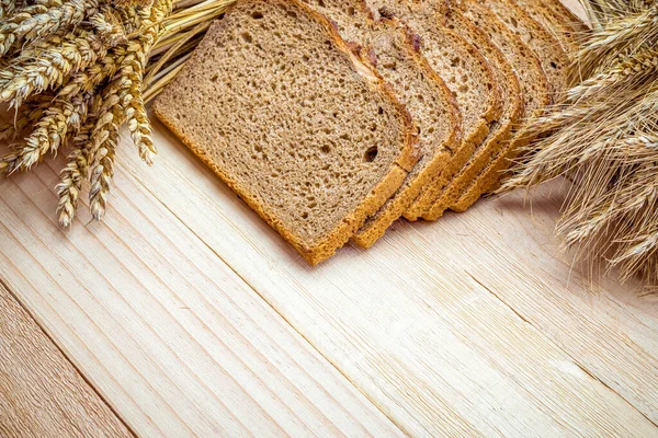 Ev yapımı ekmek. Çavdar ekmeği ve ekmek kırıntılarıyla. Buğday tohumu kulaklı taze köy ekmeği ya da doğal ahşap arka planda çivili bitki. Fırın ürün etiketi için tasarım ögesi