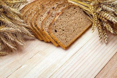 Fırın ürünleri. Çavdar ekmeği ve ekmek kırıntılarıyla. Buğday tohumu kulaklı taze bir somun ekmek ya da doğal ahşap arka planda çivili bitki. Konsept - Evde Yemek Pişirme