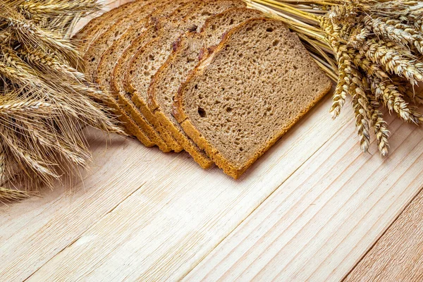 Fırın ürünleri. Çavdar ekmeği ve ekmek kırıntılarıyla. Buğday tohumu kulaklı taze bir somun ekmek ya da doğal ahşap arka planda çivili bitki. Konsept - Evde Yemek Pişirme