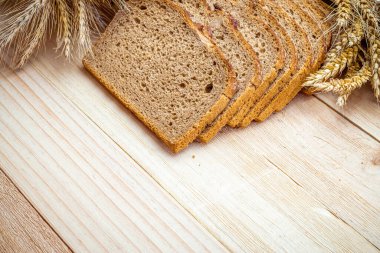 Çavdar ekmeği izole. Kabuklu somun ve ekmek kırıntılarıyla fırın. Buğday tohumu kulaklı taze bir somun ekmek ya da doğal ahşap arka planda çivili bitki. Biyolojik malzemeler, tohumlarla sağlıklı.