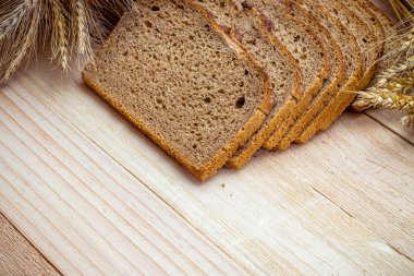 Buğday ekmeği. Buğday tohumu kulaklı bir somun taze ekmek ya da ahşap desenli bir bitki. Çavdar ekmeği ve ekmek kırıntılarıyla. Ev yapımı pişirme.