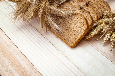 Somun ekmek. Çavdar ekmeği ve ekmek kırıntılarıyla. Buğday tohumu kulaklı taze bir somun ekmek ya da doğal ahşap arka planda çivili bitki. Biyolojik malzemeler, çok sağlıklı tohumlar.