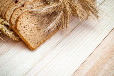 Çavdar ekmeği izole. Kabuklu somun ve ekmek kırıntılarıyla fırın. Buğday tohumu kulaklı taze bir somun ekmek ya da doğal ahşap arka planda çivili bitki. Biyolojik malzemeler, tohumlarla sağlıklı.