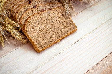 Ev yapımı ekmek. Çavdar ekmeği ve ekmek kırıntılarıyla. Buğday tohumu kulaklı taze köy ekmeği ya da doğal ahşap arka planda çivili bitki. Fırın ürün etiketi için tasarım ögesi