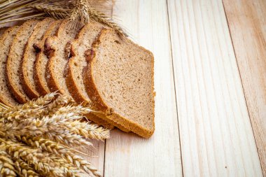 Dilimlenmiş Multigrain. Çavdar ekmeği ve ekmek kırıntılarıyla. Buğday tohumu kulaklı taze bir somun ekmek ya da doğal ahşap arka planda çivili bitki. Biyolojik malzemeler, çok sağlıklı.