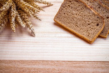 Geleneksel ekmek. Buğday tohumu kulaklı bir somun taze ekmek ya da ahşap desenli bir bitki. Çavdar ekmeği fırını. Fırın ürün etiketi için tasarım ögesi