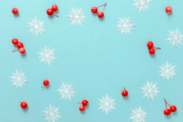 Weihnachtsdekoration Rote Beeren Weiße Schneeflocken Form Rahmen Auf Pastellblauem Hintergrund — Stockfoto