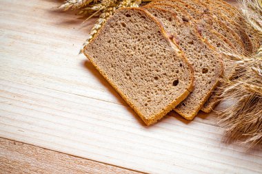 Somun ekmek. Çavdar ekmeği ve ekmek kırıntılarıyla. Buğday tohumu kulaklı taze bir somun ekmek ya da doğal ahşap arka planda çivili bitki. Biyolojik malzemeler, çok sağlıklı tohumlar.