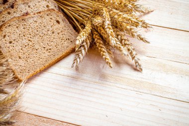 Ev yapımı ekmek. Çavdar ekmeği ve ekmek kırıntılarıyla. Buğday tohumu kulaklı taze köy ekmeği ya da doğal ahşap arka planda çivili bitki. Fırın ürün etiketi için tasarım ögesi