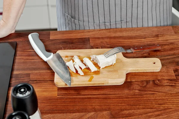 Ahşap masa üzerine dilimlenmiş tavuk göğsü ile Doğrama tahtası