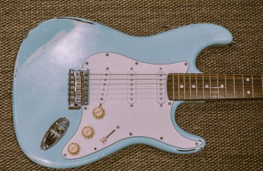 Hafif mavi elektro gitar bir doku arka planda. Yaş yıpranmış gitar