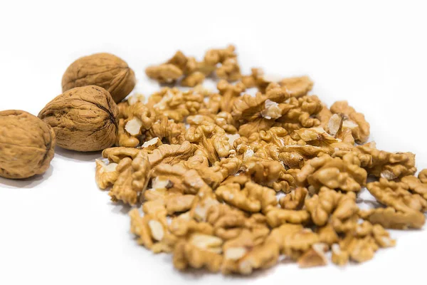 Ceviz taneleri ve bütün nutshells closeup makro, beyaz bir arka plan üzerinde izole. Kurutulmuş meyve