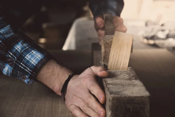 Vintage carpenter working on wood using wood retro vintage old ancient planer. Workshop background. — Stock Photo, Image