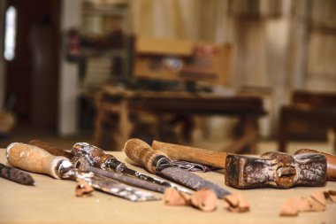Carpenter tools. Chisel or gouge for wood on carpenter working at workbench. Carpentry workshop clipart