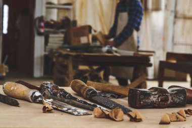 Marangoz aletleri. İş tezgahında çalışan marangoz üzerinde ahşap için kesya veya çiselme. Maranyesiz Atölyesi