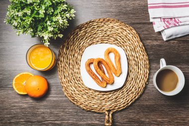 Lezzetli İspanyol churros, portakal suyu, kahve kahvaltı. Turuncu dilimlenmiş. Churros ile masa üstü.