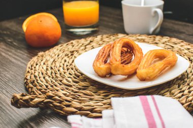 Lezzetli İspanyol churros, portakal suyu, kahve kahvaltı. Turuncu dilimlenmiş.