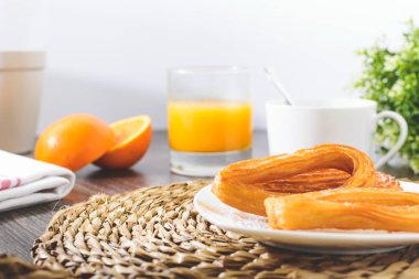 Lezzetli İspanyol churros, portakal suyu, kahve kahvaltı. Turuncu dilimlenmiş. Churros ile masa üstü.
