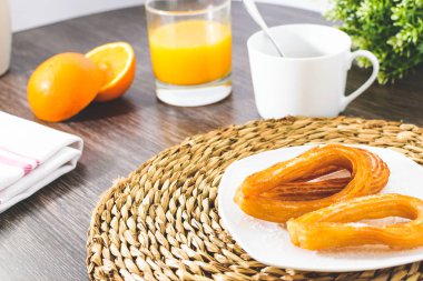 Lezzetli İspanyol churros, portakal suyu, kahve kahvaltı. Turuncu dilimlenmiş. Churros ile masa üstü.