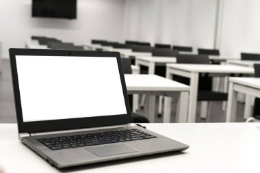 Dizüstü bilgisayar, online iş, öğretmen sınıfta çalışır. Dizüstü bilgisayar bir masaya veya masaya konur